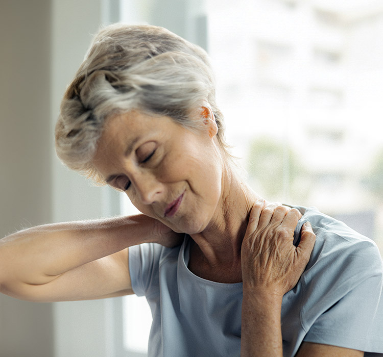 Une femme qui se tient l'épaule à cause de la douleur